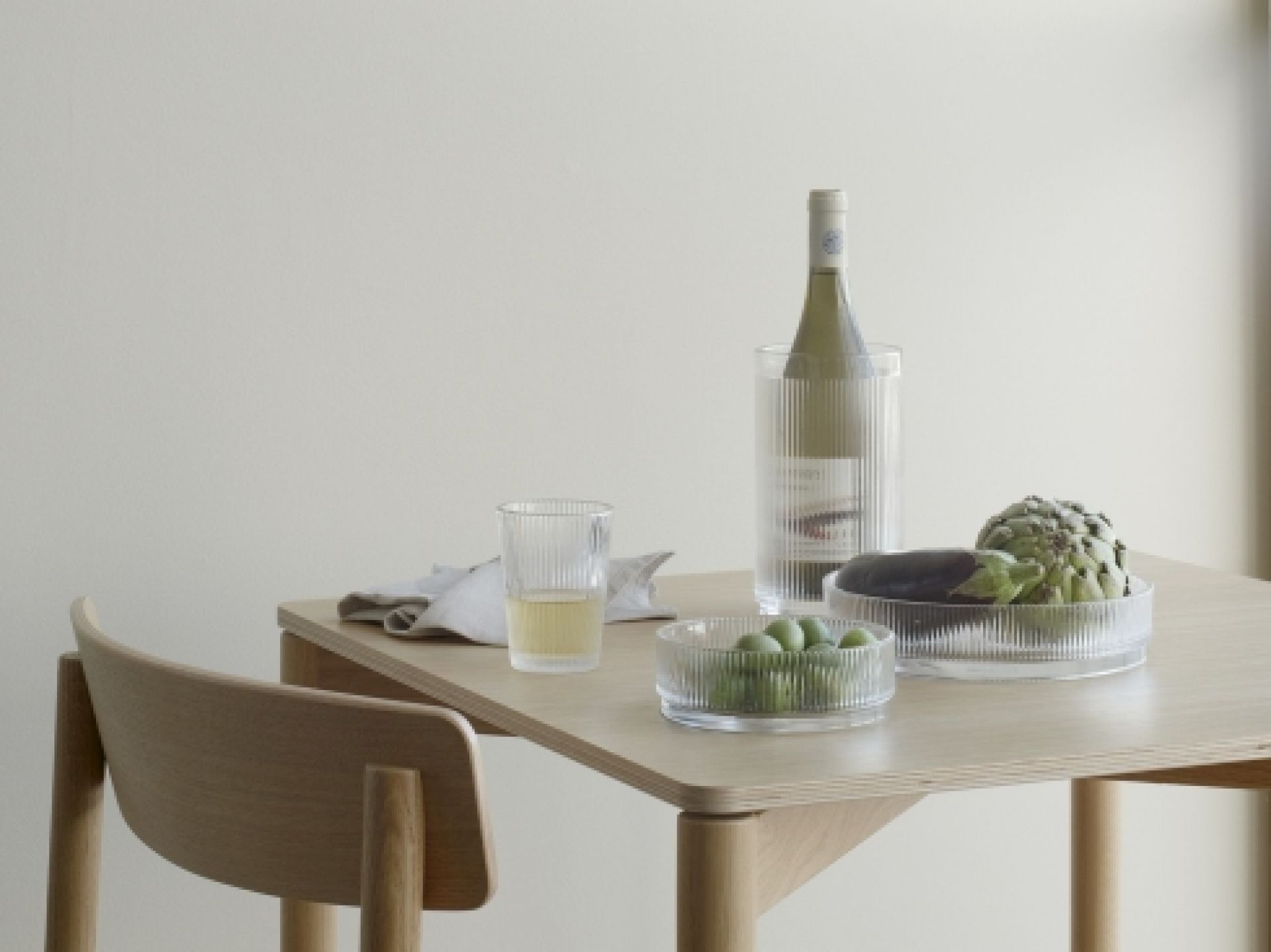 Pilastro Servierschale klein von Stelton: Glas-Schale mit Oliven, Artischocke und Aubergine auf einem Tisch.