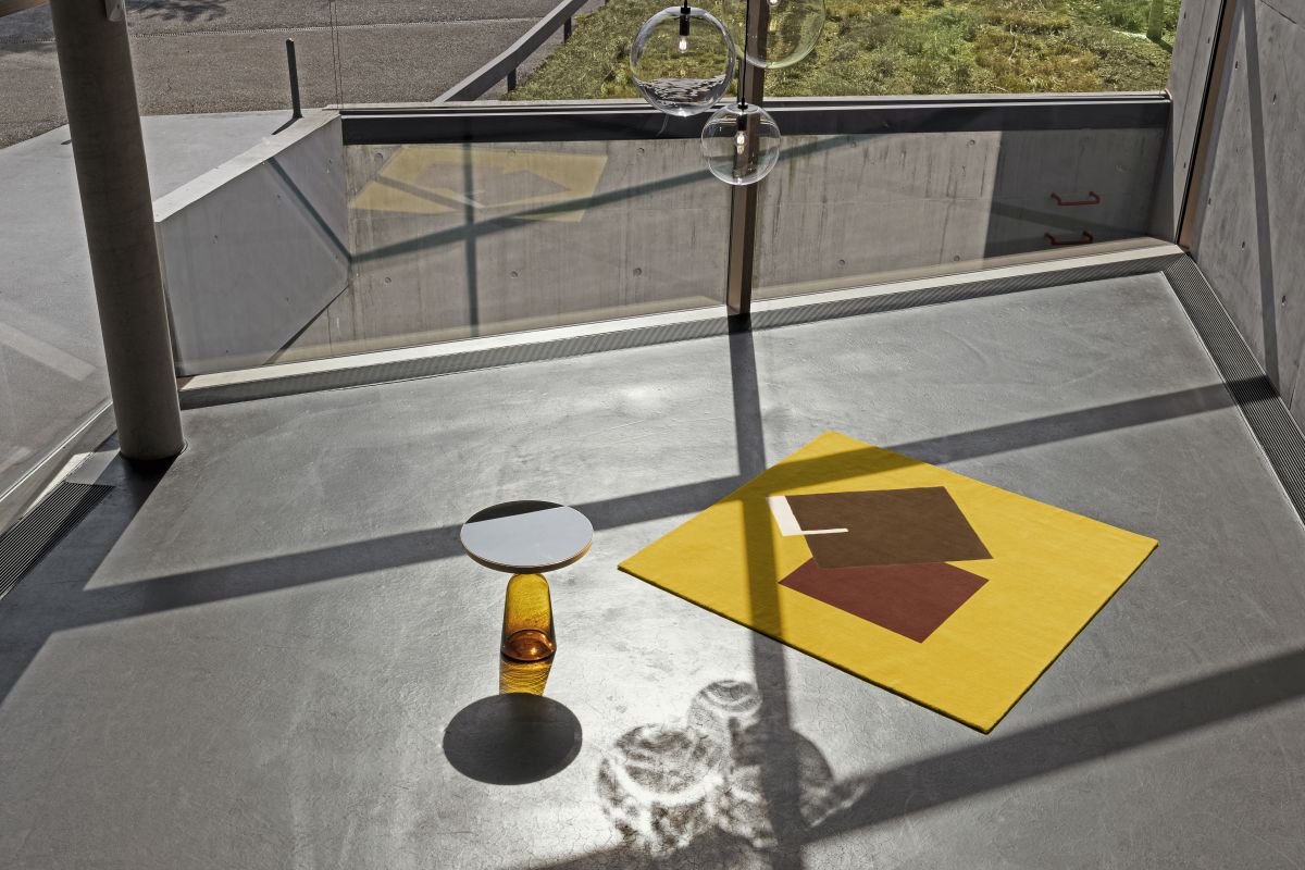 Gelber Castellar Teppich mit geometrischem Muster, 300x250cm, neben einem Beistelltisch in modernem Raum.