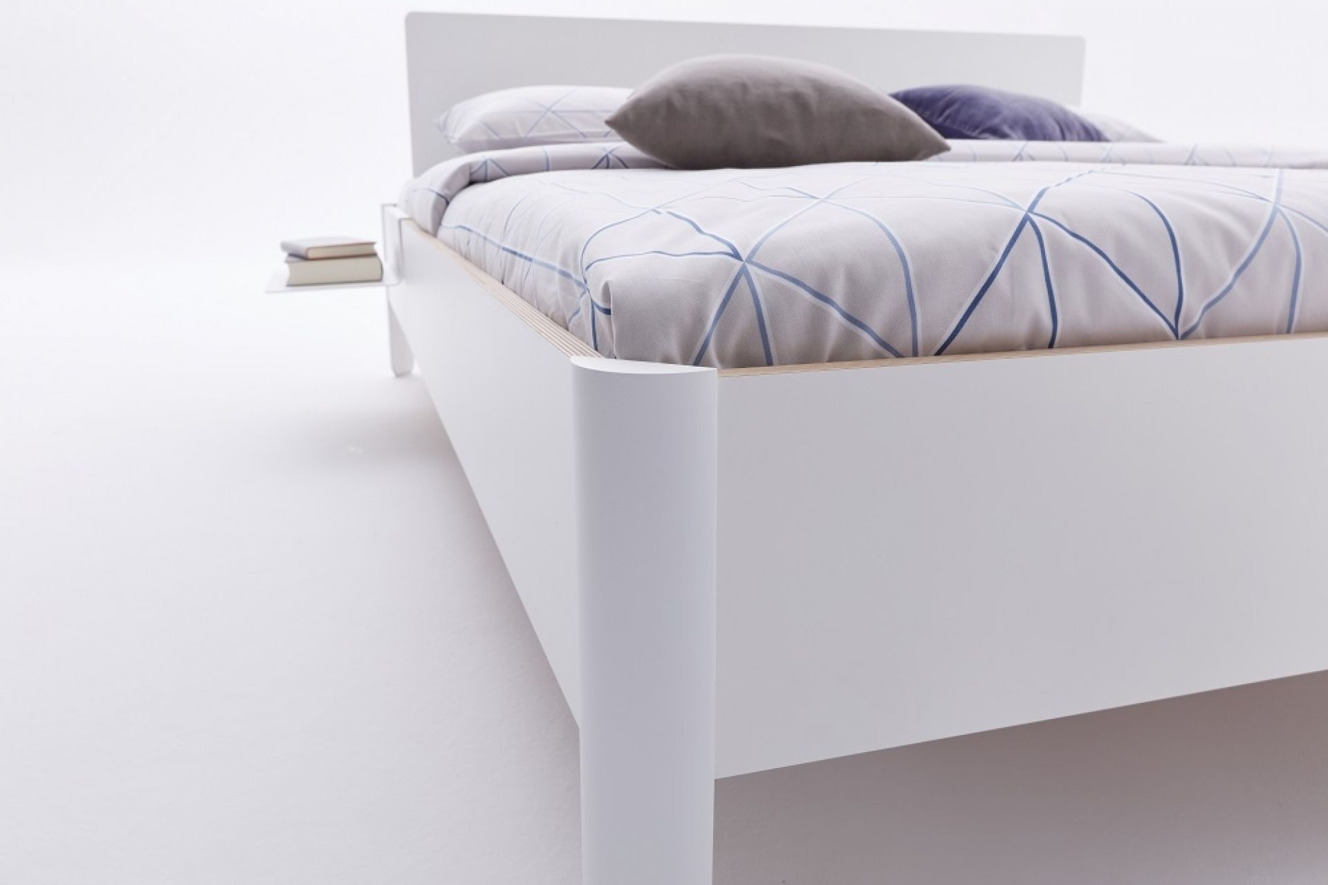 Weißes Nait Bett von Müller Möbelwerkstätten mit Bettwäsche und Nachttisch im minimalistischen Design.
