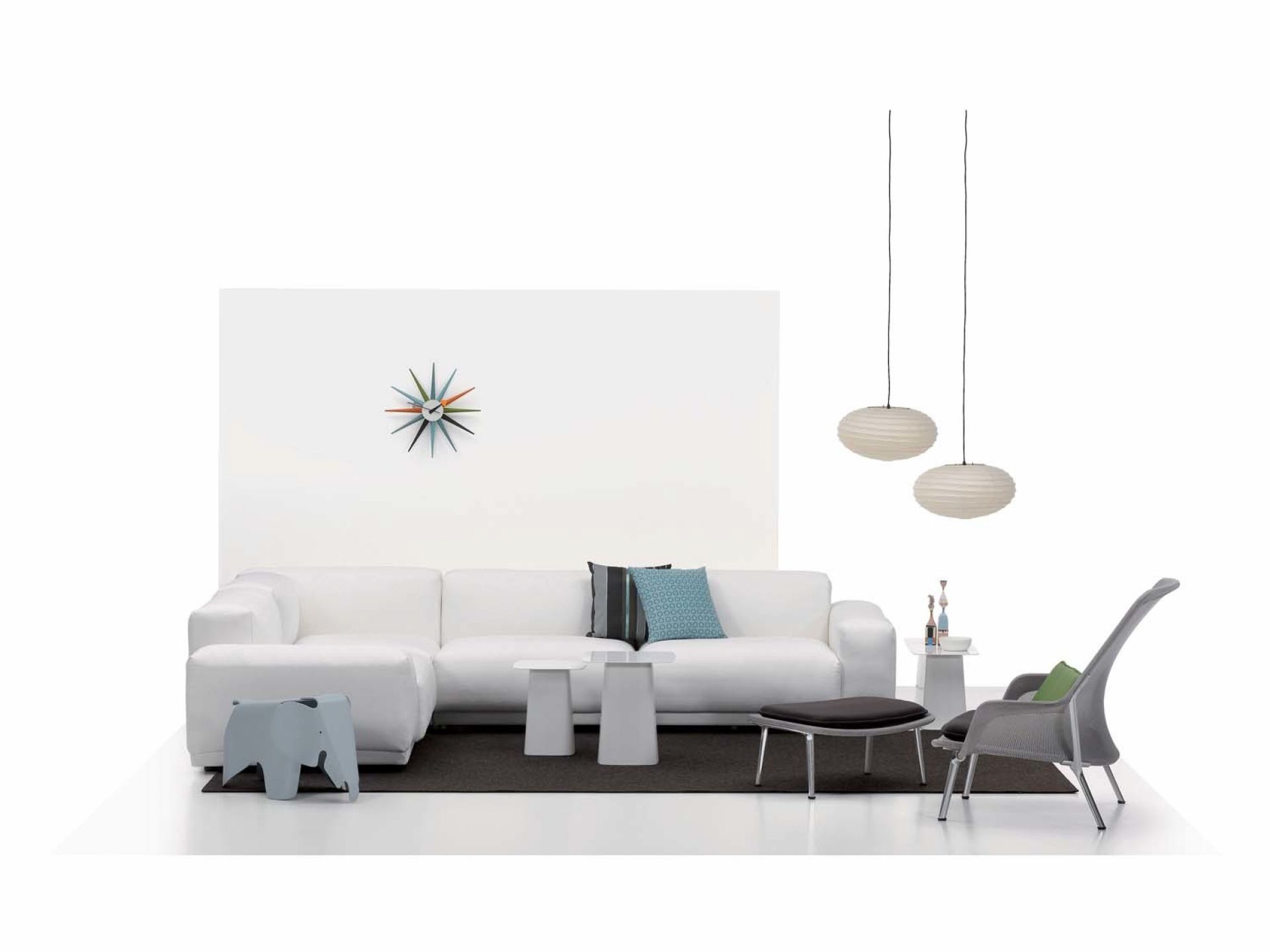 Mehrfarbige Sunburst Clock Wanduhr von Vitra im modernen Wohnzimmer-Interieur. Designklassiker für stilvolle Dekoration.