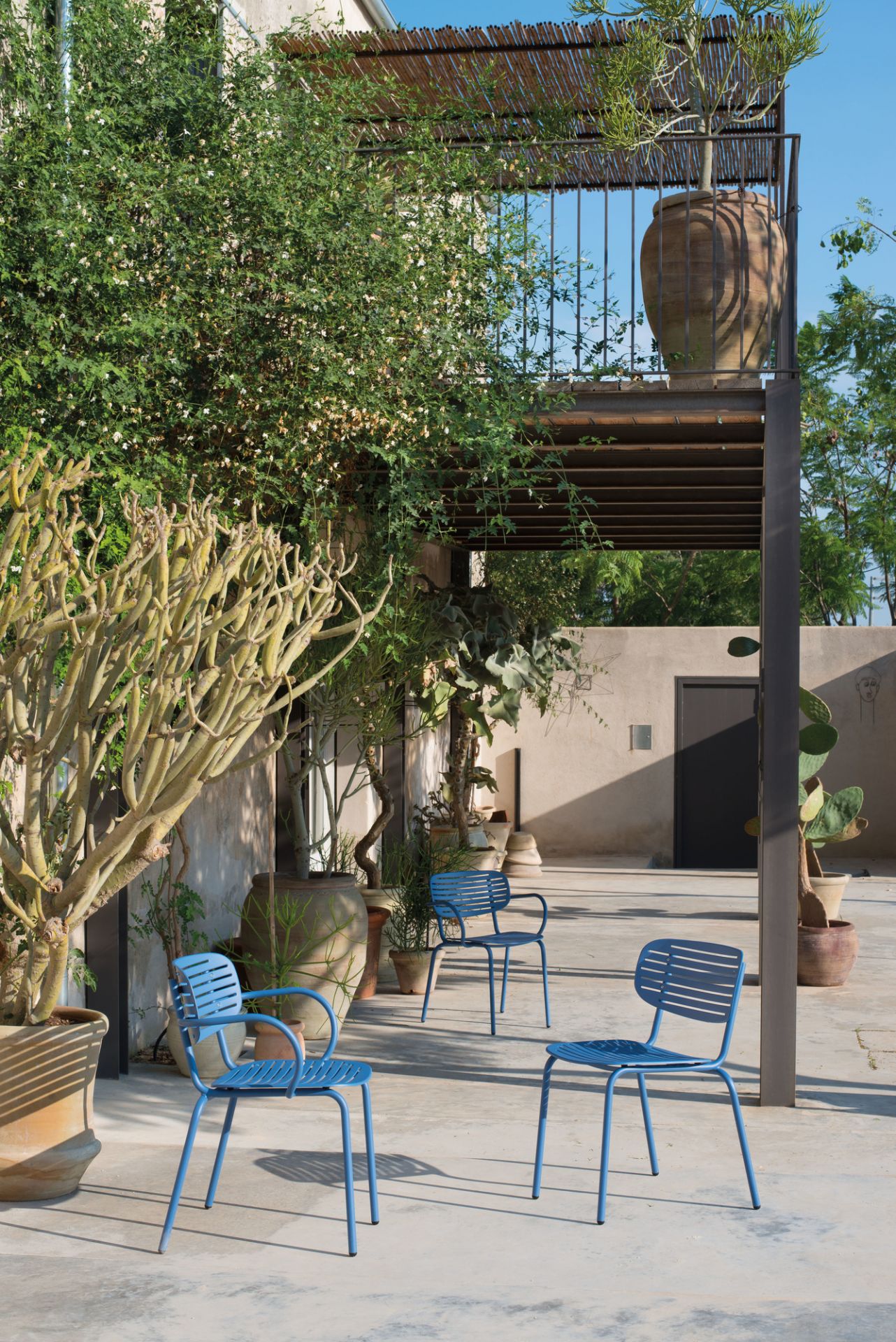 Drei blaue Emu Stühle im Außenbereich, Gartenmöbel für Terrasse und Balkon.
