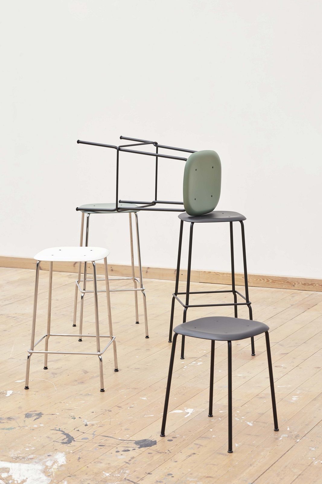 Mehrere Hay Soft Edge Hocker in verschiedenen Farben und Ausführungen auf einem Holzboden.