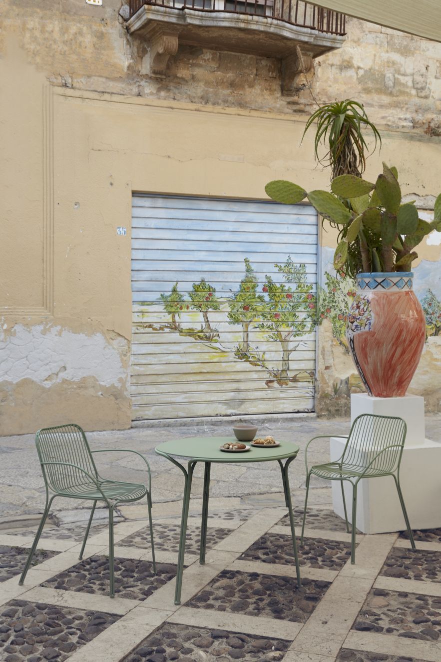 Grüne Hiray Outdoor Stühle mit Armlehnen und Tisch von Kartell im Außenbereich. Gartenmöbel für Terrasse.
