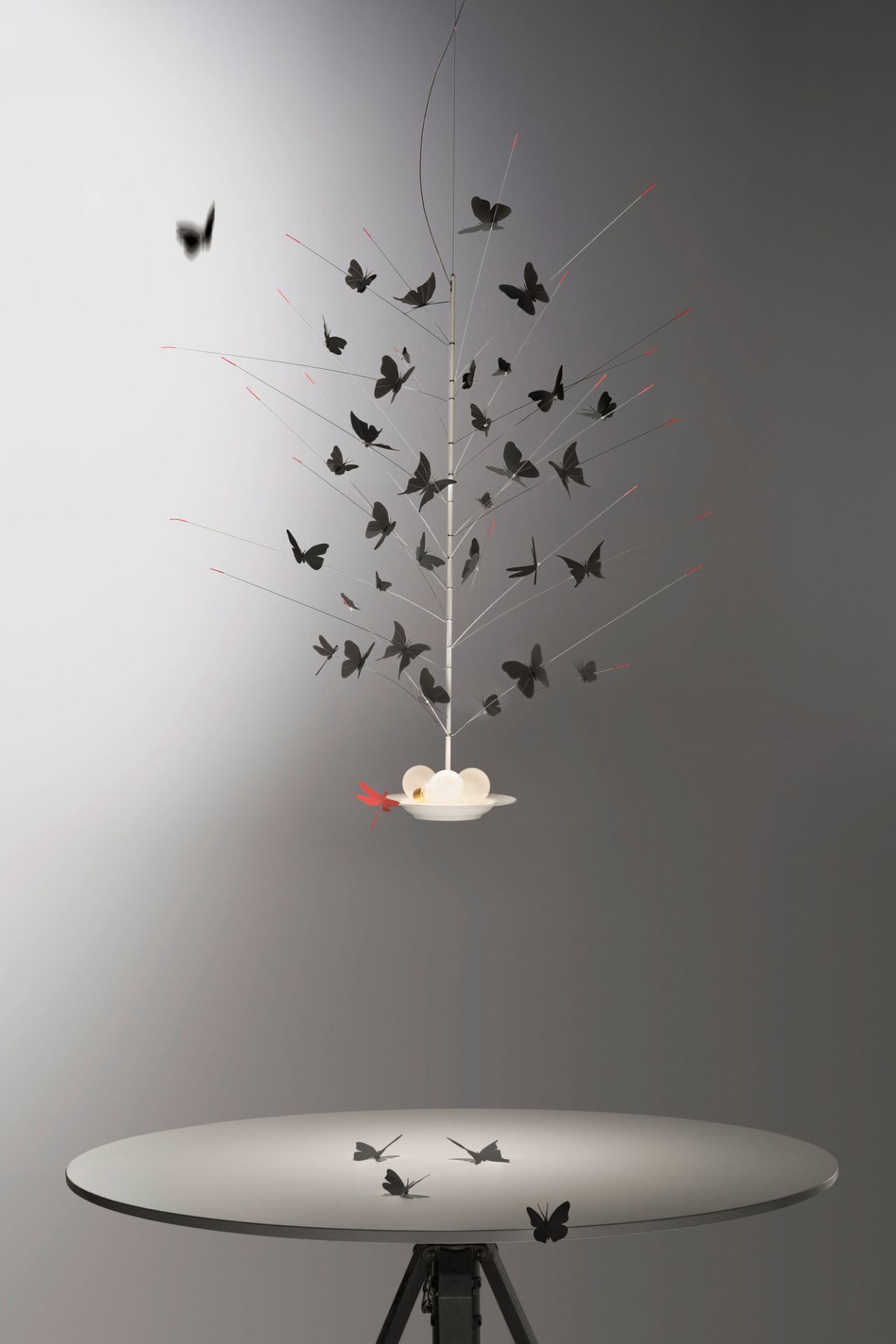 Detailaufnahme der Ingo Maurer "Farfalle" Deckenleuchte mit vielen schwarzen Schmetterlingen und roter Libelle.