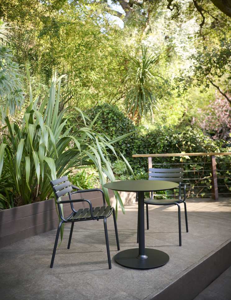 Houe Pico Café Table: Runder, schwarzer Beistelltisch und Stühle für den Outdoor-Bereich im Garten.