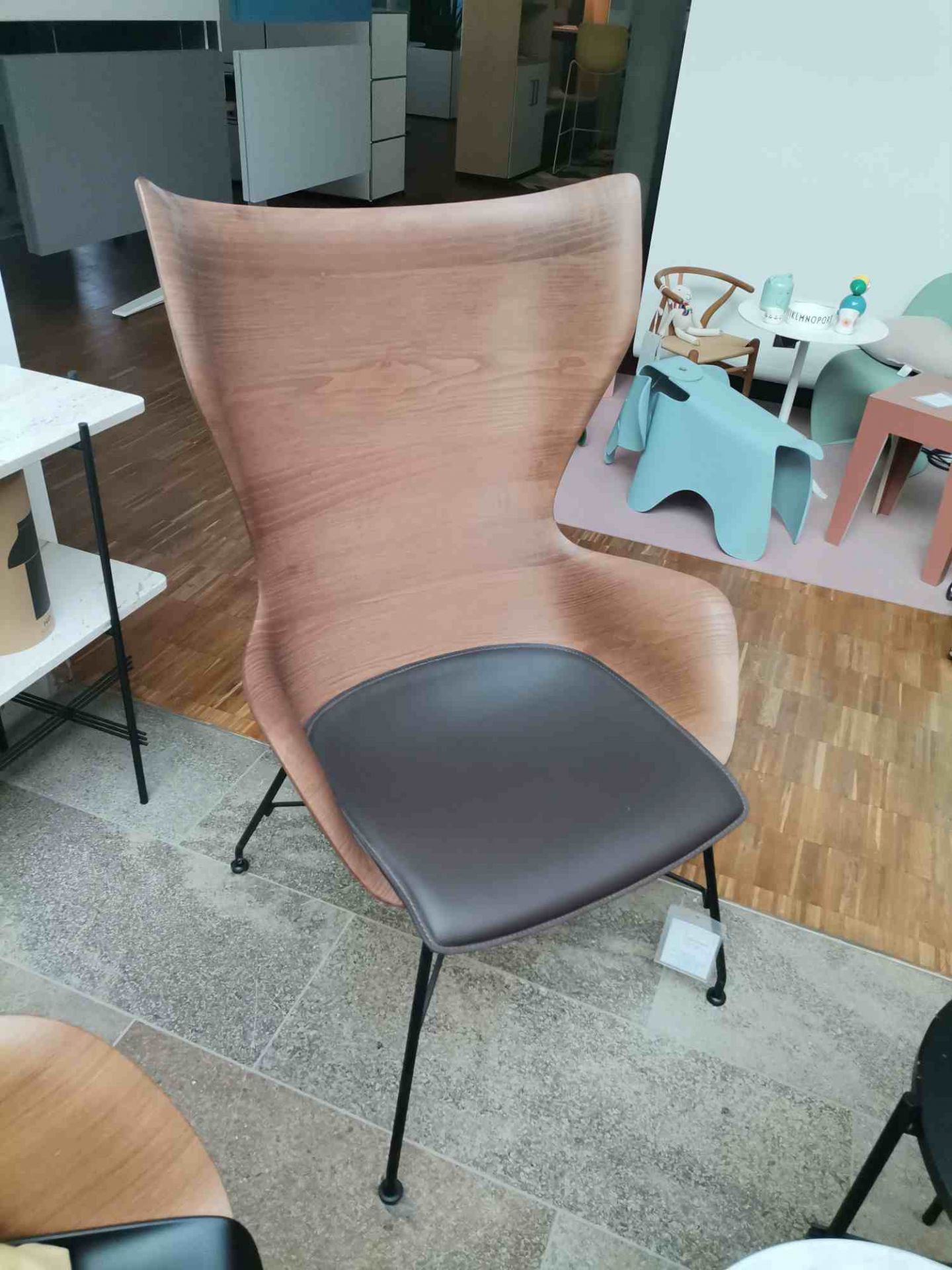 K/WOOD Sessel: Ausstellungsstück mit Holzschale und schwarzem Sitzpolster, modernes Design für Wohnzimmer und Büro.