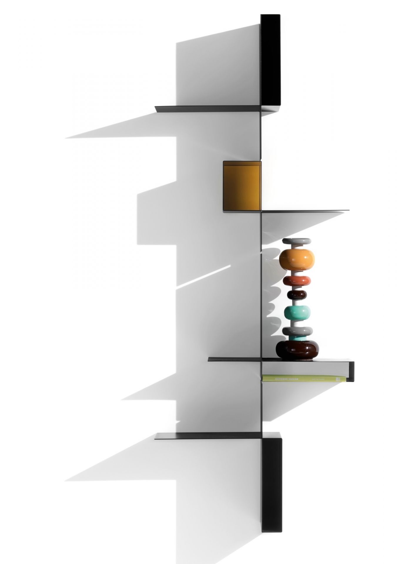 Schwarzes Randomissimo Regalsystem von MDF Italia mit Deko-Objekten vor weißem Hintergrund. Designermöbel für Wohnzimmer.