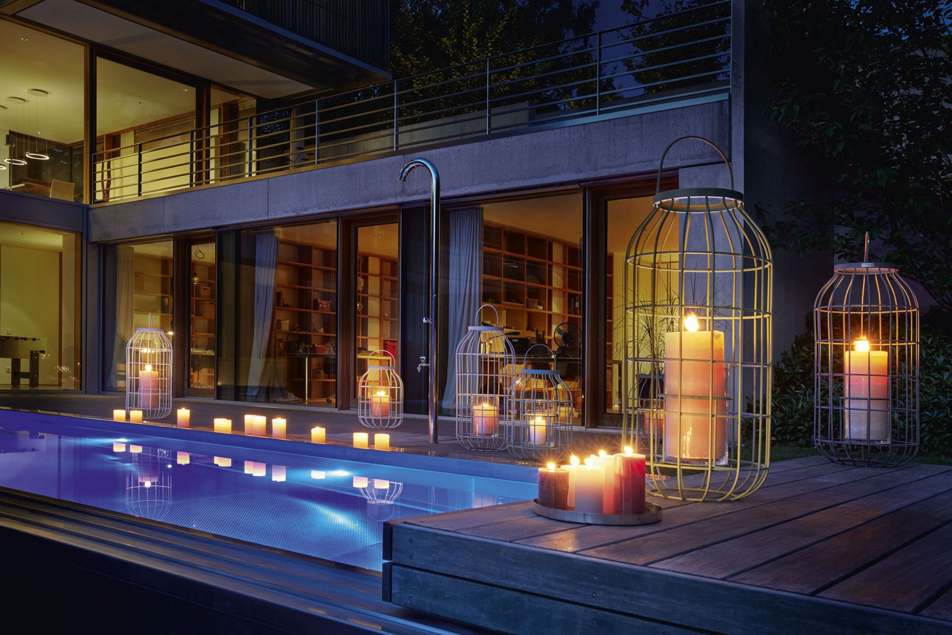 Weishäupl Laterne Outdoor neben Pool mit brennenden Kerzen für stimmungsvolle Gartenbeleuchtung und Dekoration.