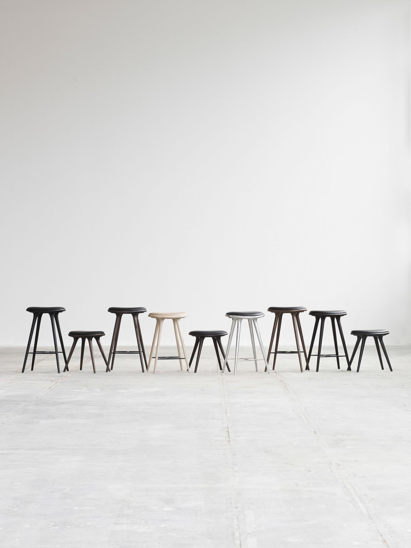 Reihe verschiedener Barhocker, inklusive schwarzem High Stool Barhocker aus Buche, vor weißem Hintergrund.