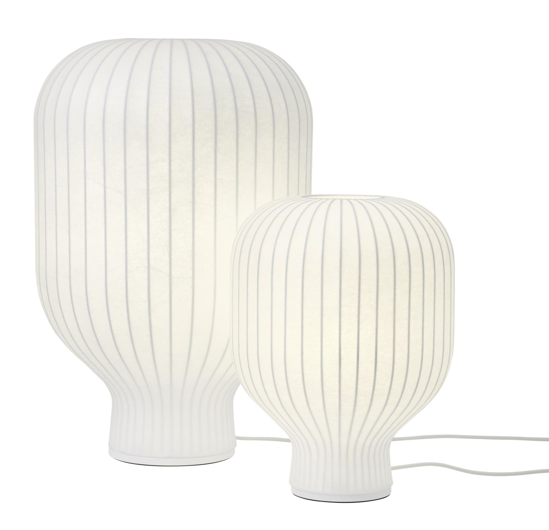 Zwei weiße Muuto Strand Tischleuchten mit geripptem Lampenschirm für stimmungsvolle Beleuchtung.