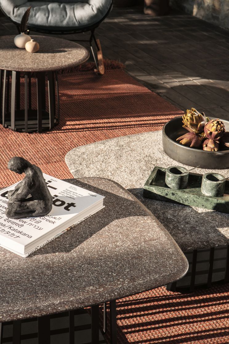 BC 09 Basket Outdoor Couchtisch von Janua, Profido Viola, mit Dekoration auf einer Terrasse.