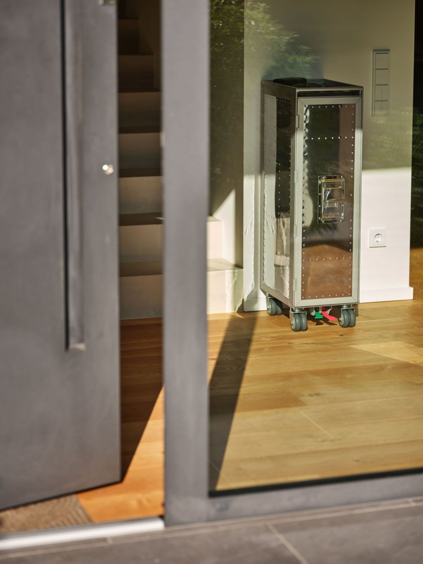 Rivet Rocker Flugzeugtrolley Bordbar mit Fenster, silberfarben, auf Holzfußboden, modernes Design.