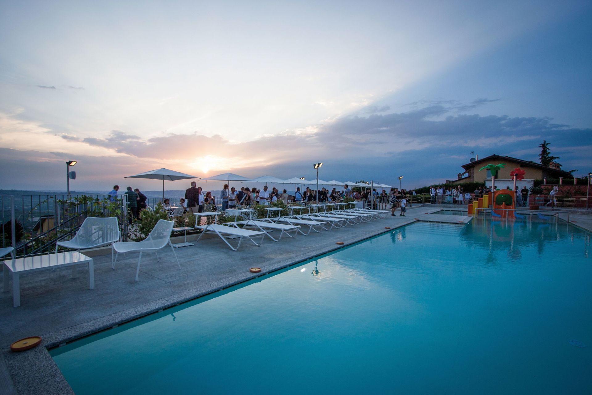 Weiße Emu Holly Sonnenliegen am Pool bei Sonnenuntergang, ideal für Garten und Terrasse.