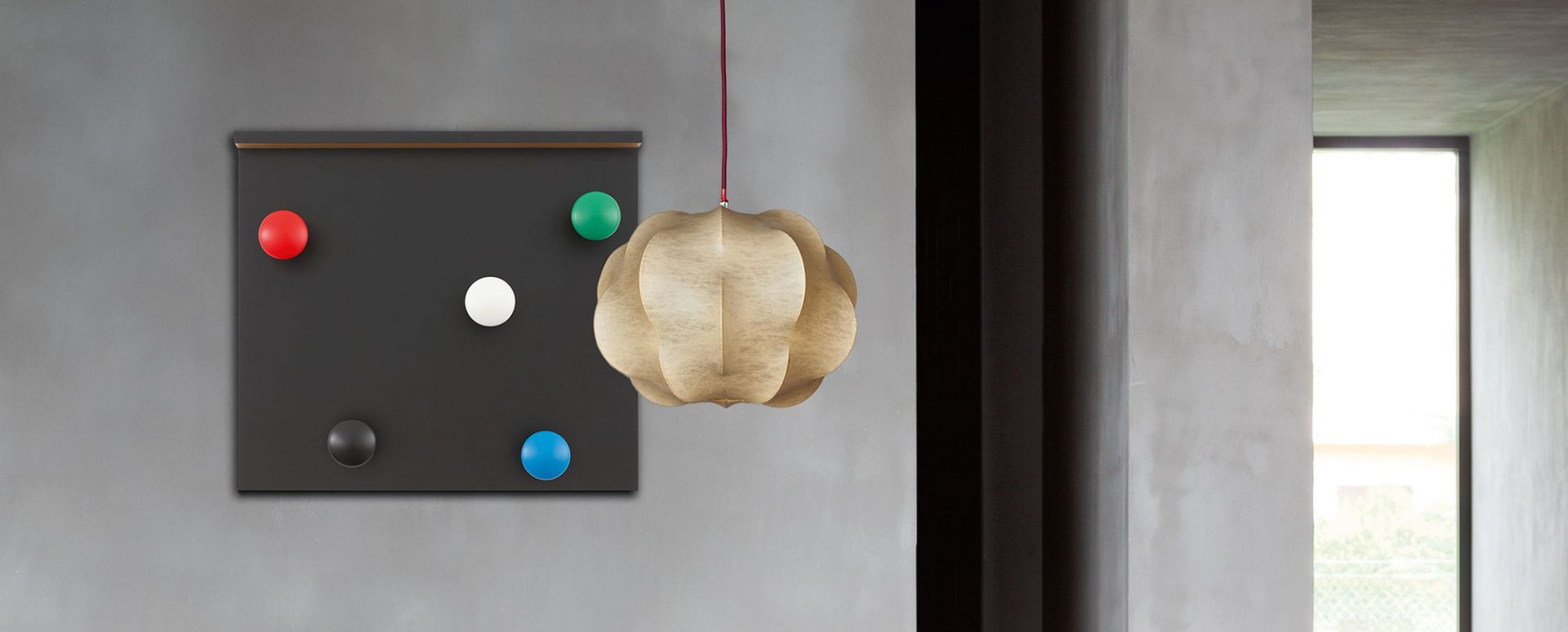 LC17 Cassina Portemanteau Garderobe mit farbigen Knöpfen und Designerlampe im modernen Interieur.