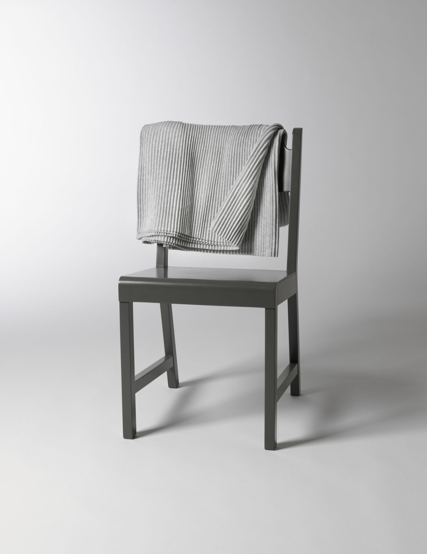 Helle Pleece Throw Decke von Design House Stockholm, hellgraue Kuscheldecke auf einem Stuhl.