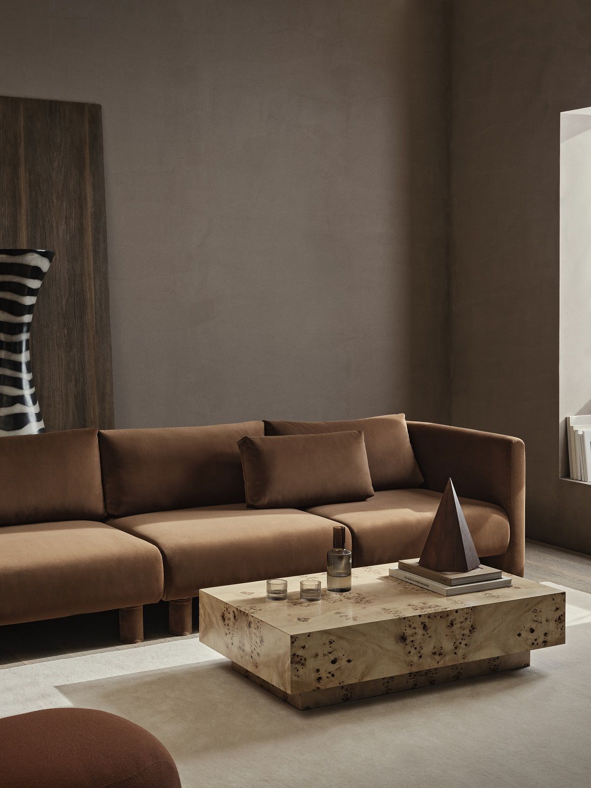 Wohnzimmer-Szene mit braunem Sofa und Ferm Living Burl Coffee Table aus Naturholz.