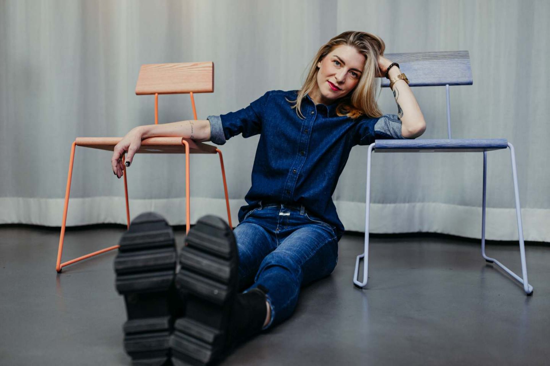 Frau lehnt an D:005 Stühlen von Fuchs & Habicht, Design Stühle in Weiß und Orange.