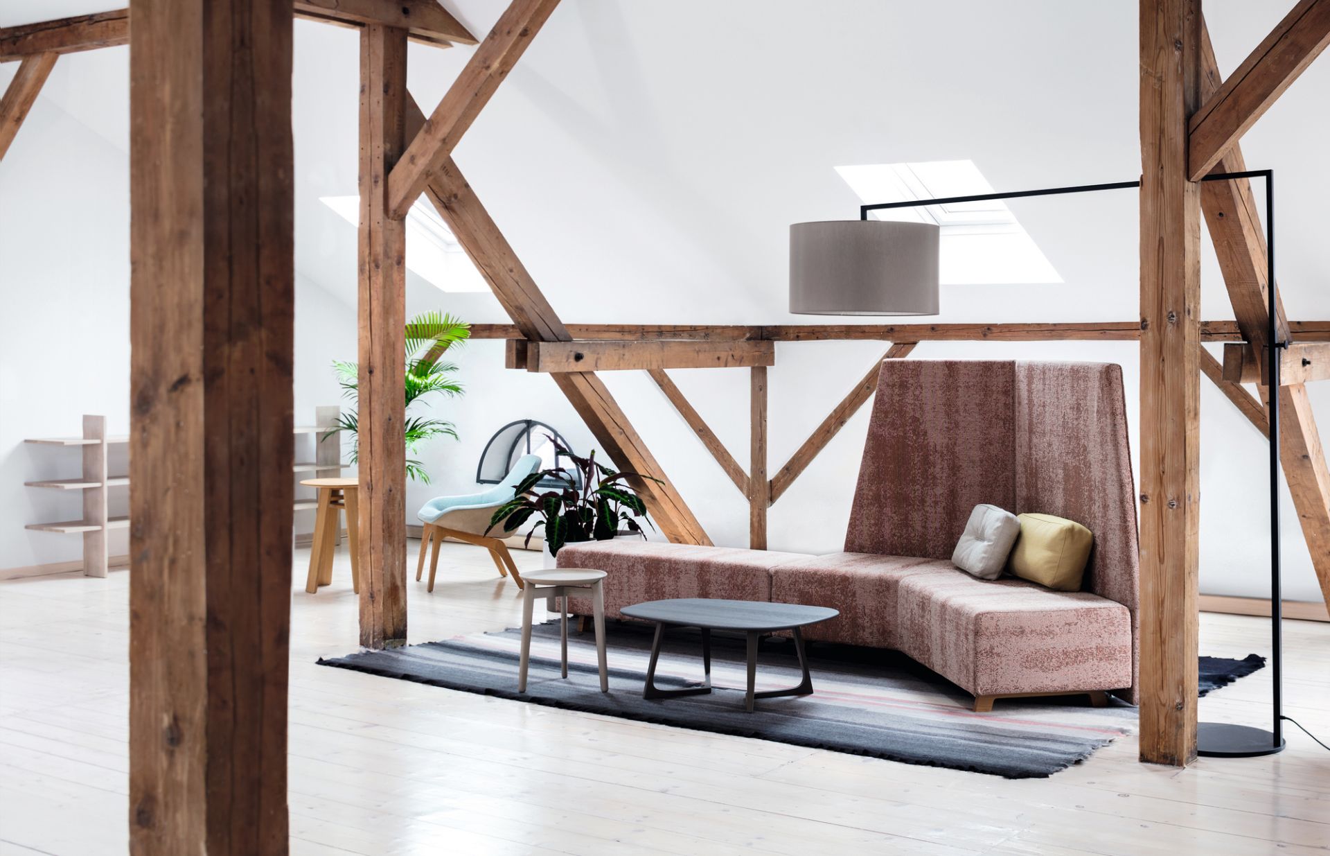 High Noon Stehleuchte in lichtgrau im Loft-Ambiente mit Sofa und Holzbalken.