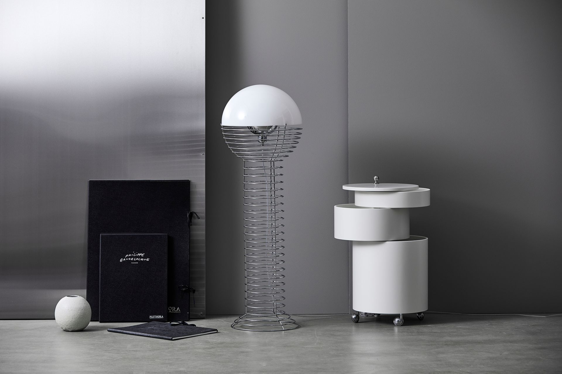 Verpan Wire Stehleuchte mit weißem Kugelschirm und filigranem Drahtgestell, neben weißem Beistelltisch in modernem Ambiente.