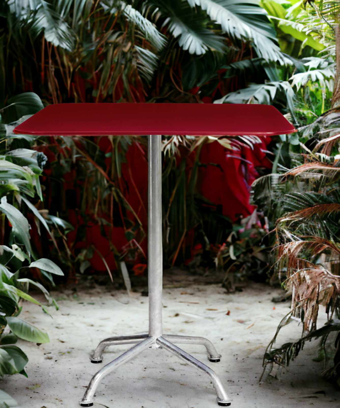 Roter Haefeli Gartentisch mit silbernem Gestell vor üppigem Grün. Outdoor-Tisch für Garten und Terrasse.
