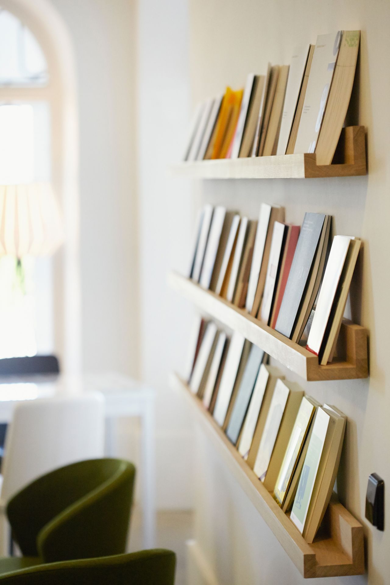 Drei Ell Wandregale von Jan Kurtz mit Büchern an einer weißen Wand. Holzregal für Bücher.