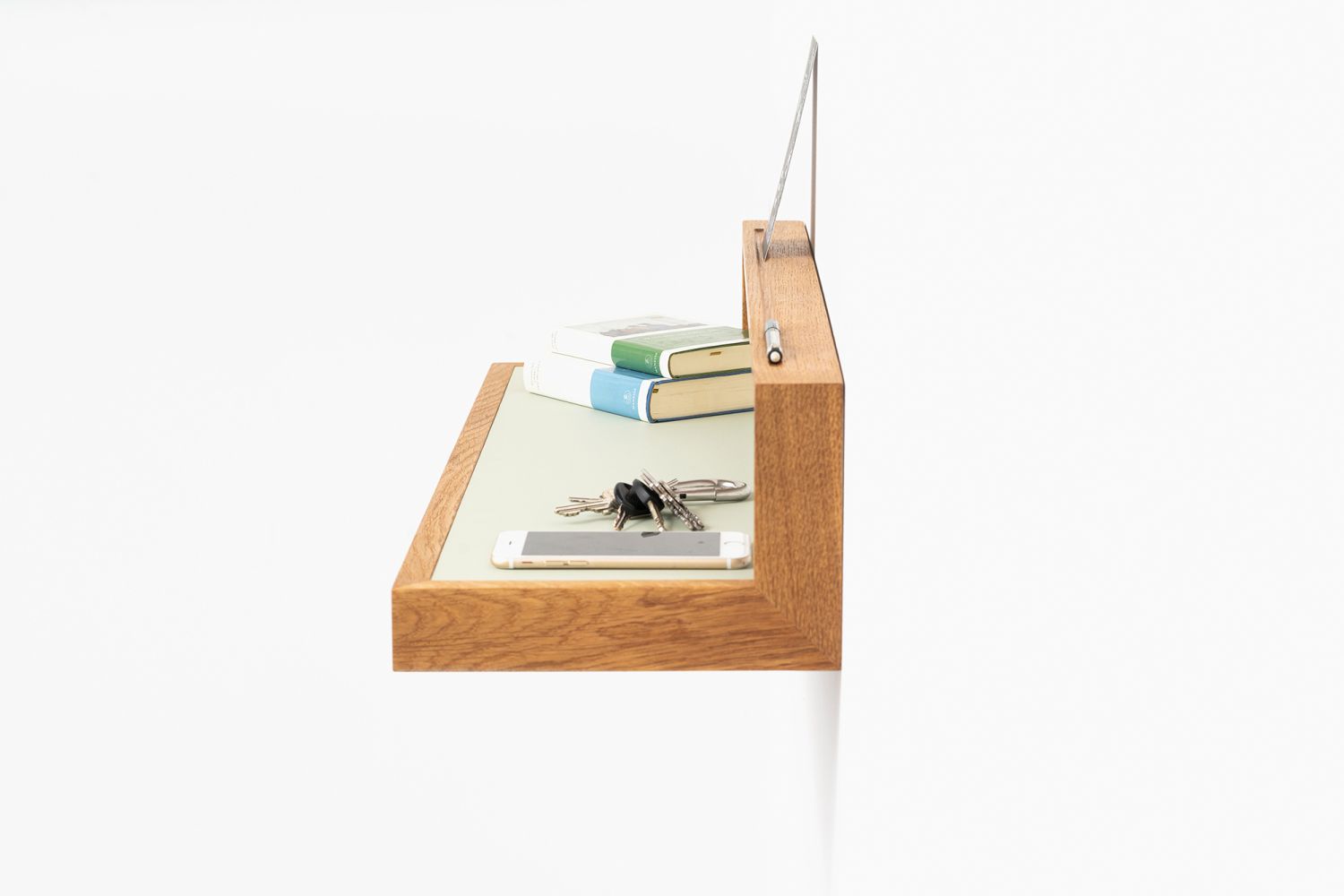 Ablageboard buck3 in Pistazie: Wandboard aus Holz mit Ablage für Bücher, Schlüssel und Smartphone.