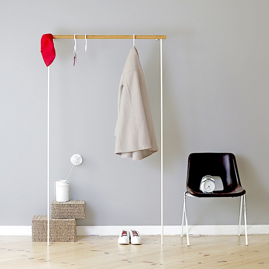 Weiße Leanon II Anlehngarderobe von Roomsafari mit Kleidung, Schlüsseln und Dekoration im minimalistischen Flur.