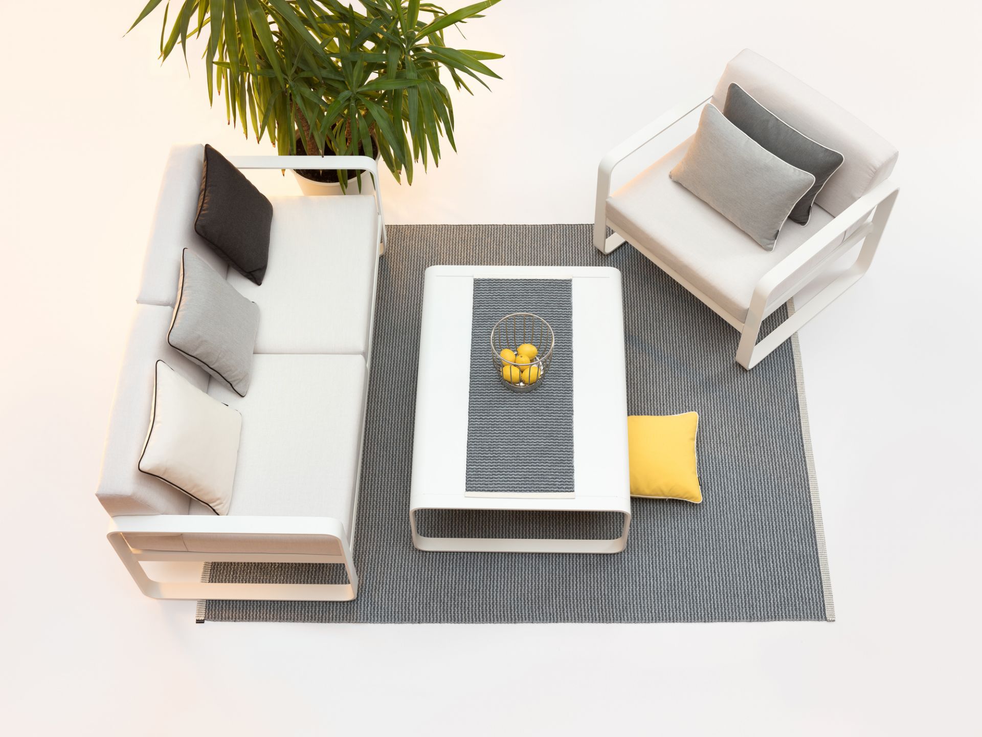 Pappelina Mono Teppich 140x200 cm in Grau, mit Möbeln und Pflanze auf weißem Hintergrund.