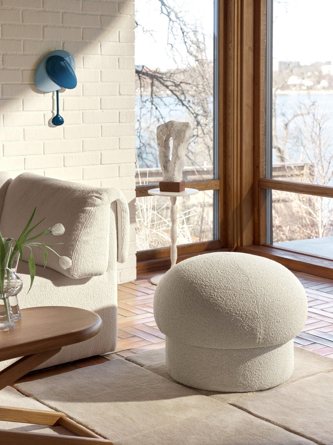 Beiger Uno Pouf Hocker von Design House Stockholm im hellen Wohnzimmer mit Fenster und Dekoration.