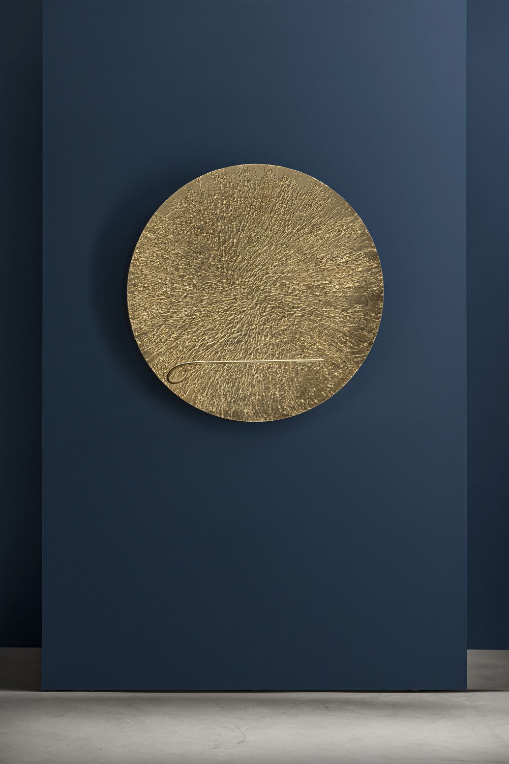 Goldene Bellatrix Wandleuchte von Catellani & Smith an blauer Wand. Runde Designleuchte für Wohnzimmer.