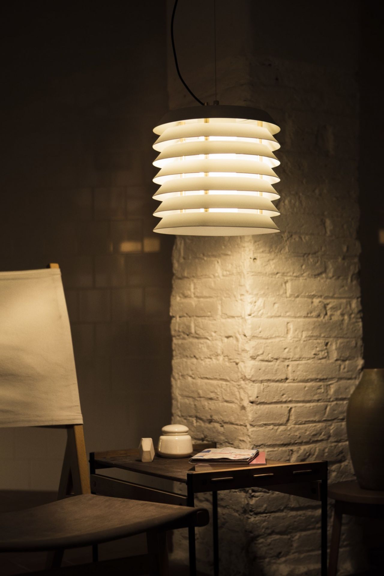 Nahaufnahme der beleuchteten Santa & Cole Maija Hängeleuchte mit schirmförmigen Design, warmes Licht.