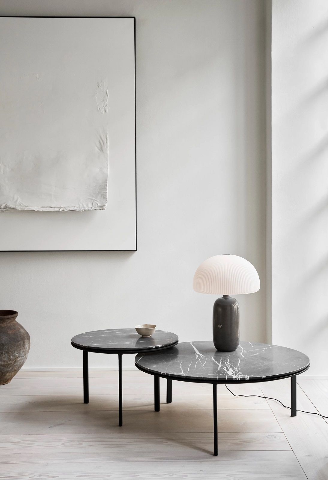 Zwei runde Couchtische von Vipp mit Marmorplatte und schwarzem Gestell im Interieur.