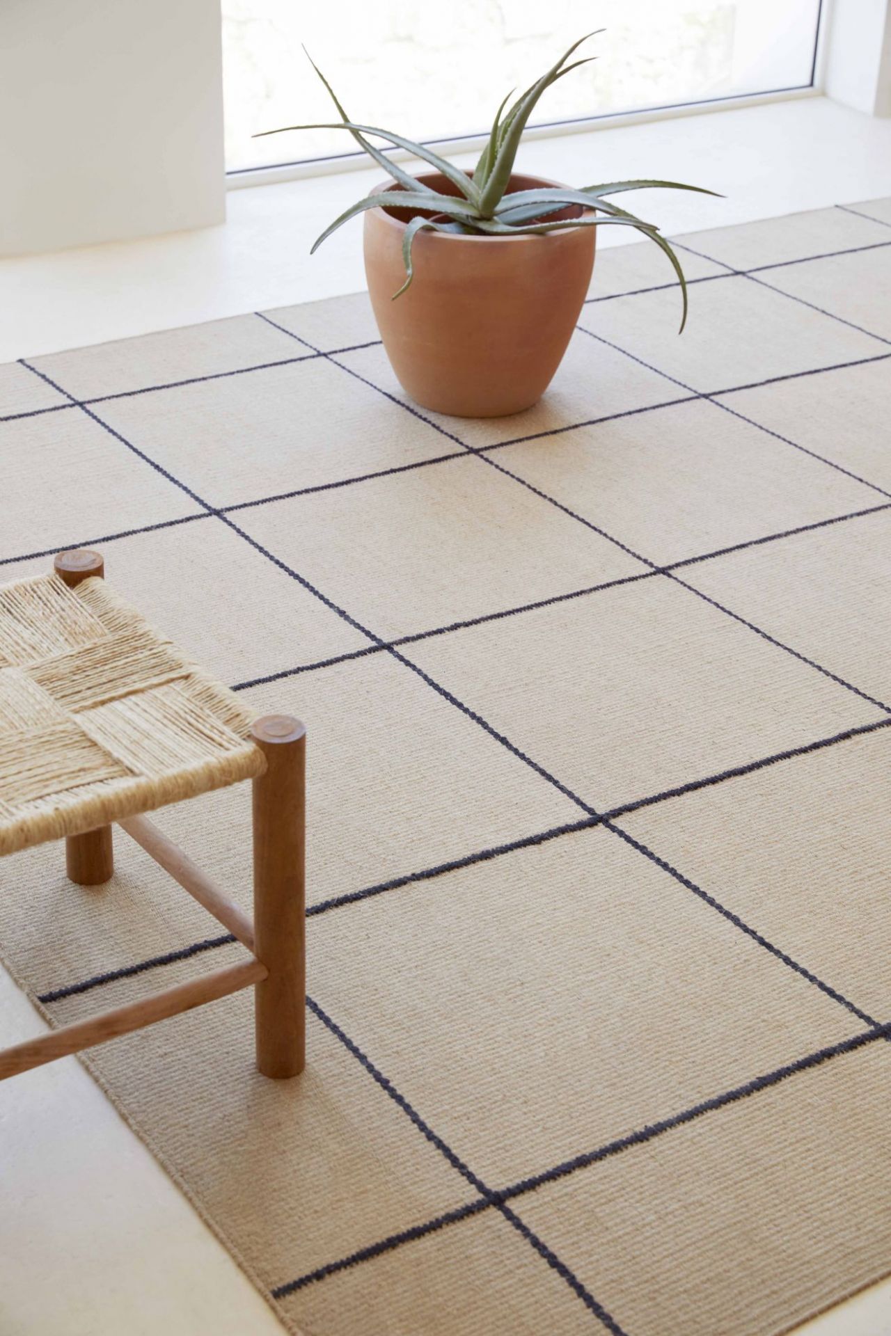 Roots Teppich mit grafischem Muster in Beige und Dunkelblau, natürlicher Look für Wohnzimmer und Schlafzimmer.