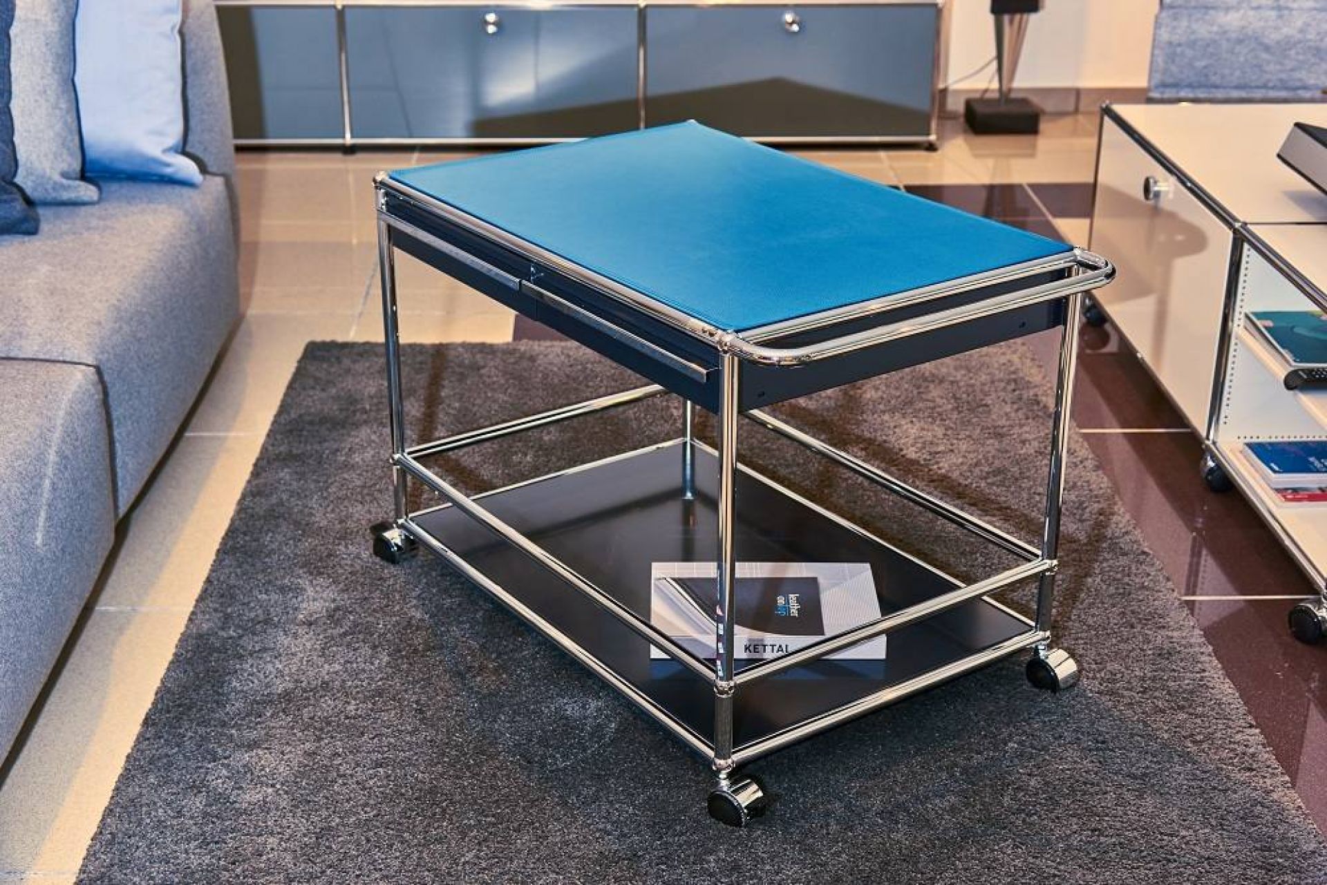 USM Servierwagen mit blauer Lederauflage (75x50 cm) im modernen Wohnzimmer. Hochwertige Ledermatte für USM Möbel.