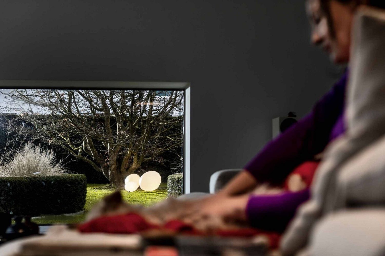 Gregg Outdoor Leuchte von Foscarini im Garten, gesehen durch ein Fenster. Bodenleuchte, Gartenleuchte.