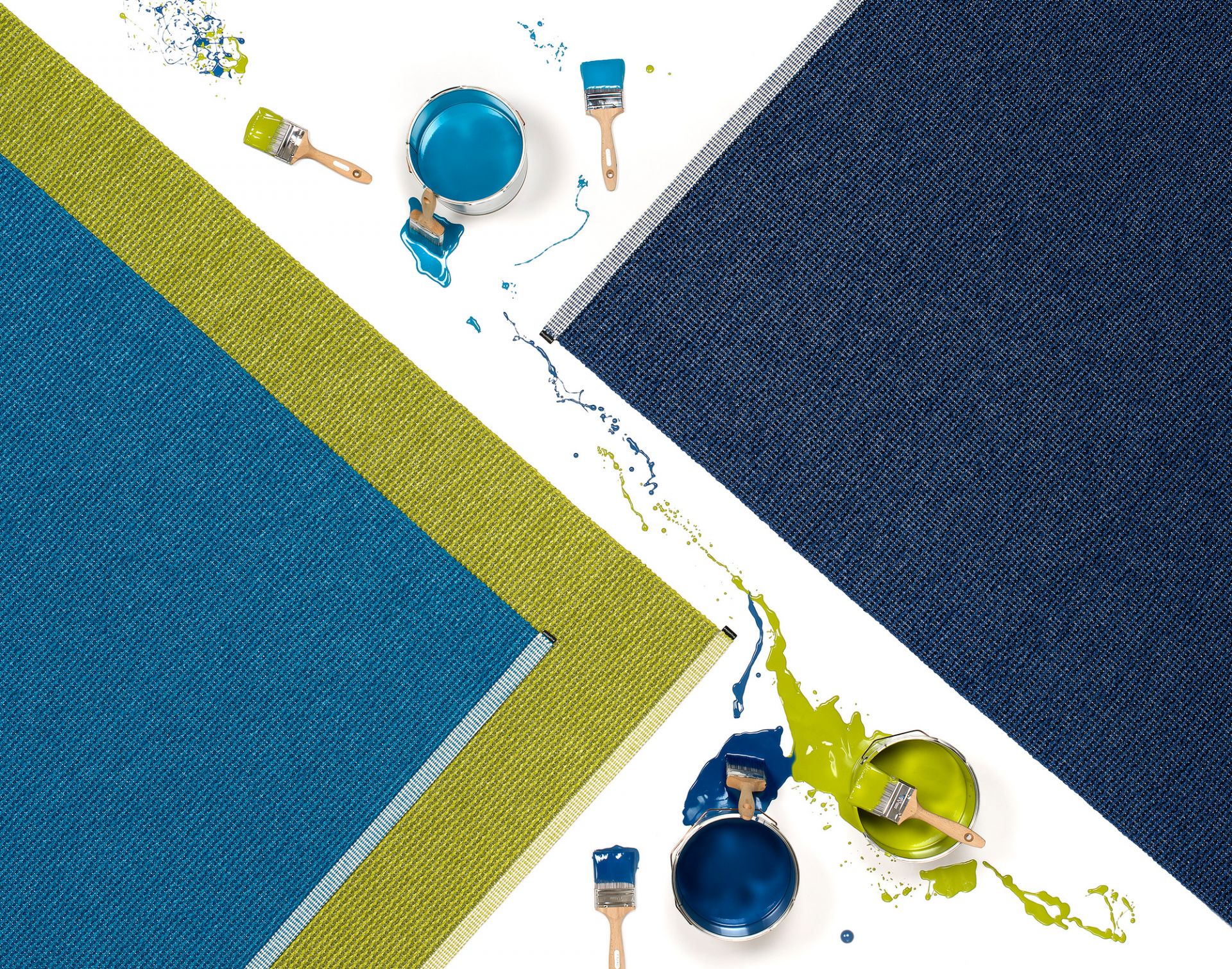 Pappelina Mono Kunststoffteppich 85x160 cm: Detailaufnahme des Teppichs mit Farbtöpfen und Pinsel.