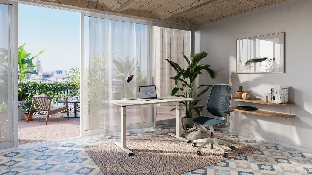 Büro mit Steelcase Karman Bürodrehstuhl, höhenverstellbarem Schreibtisch und Blick auf eine sonnige Terrasse.