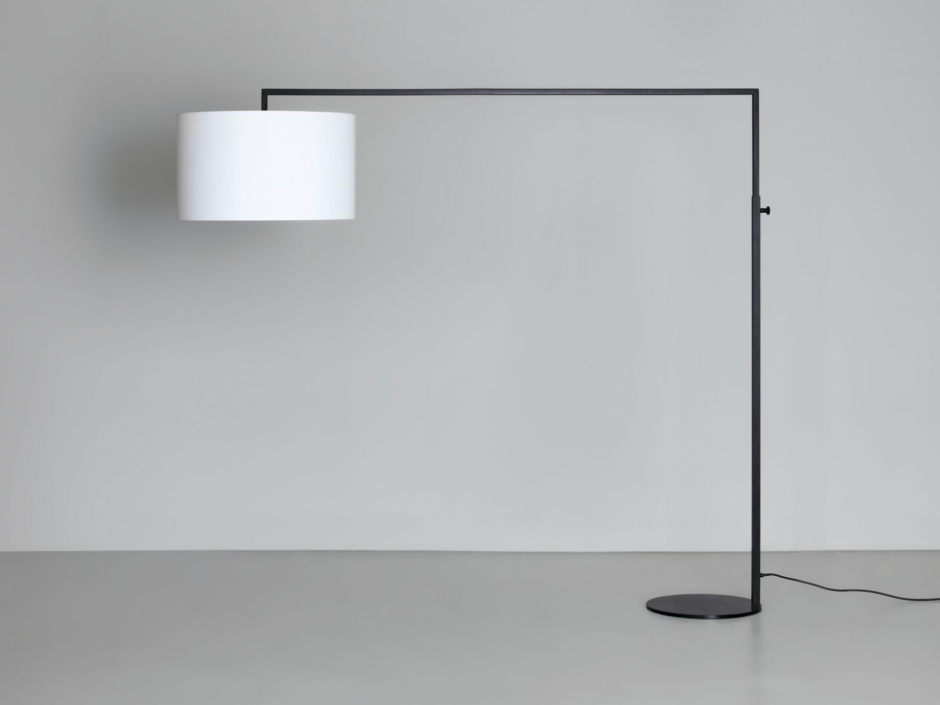 High Noon Stehleuchte in Weiß: Moderne Stehlampe mit zylindrischem Lampenschirm und schwarzem Gestell.