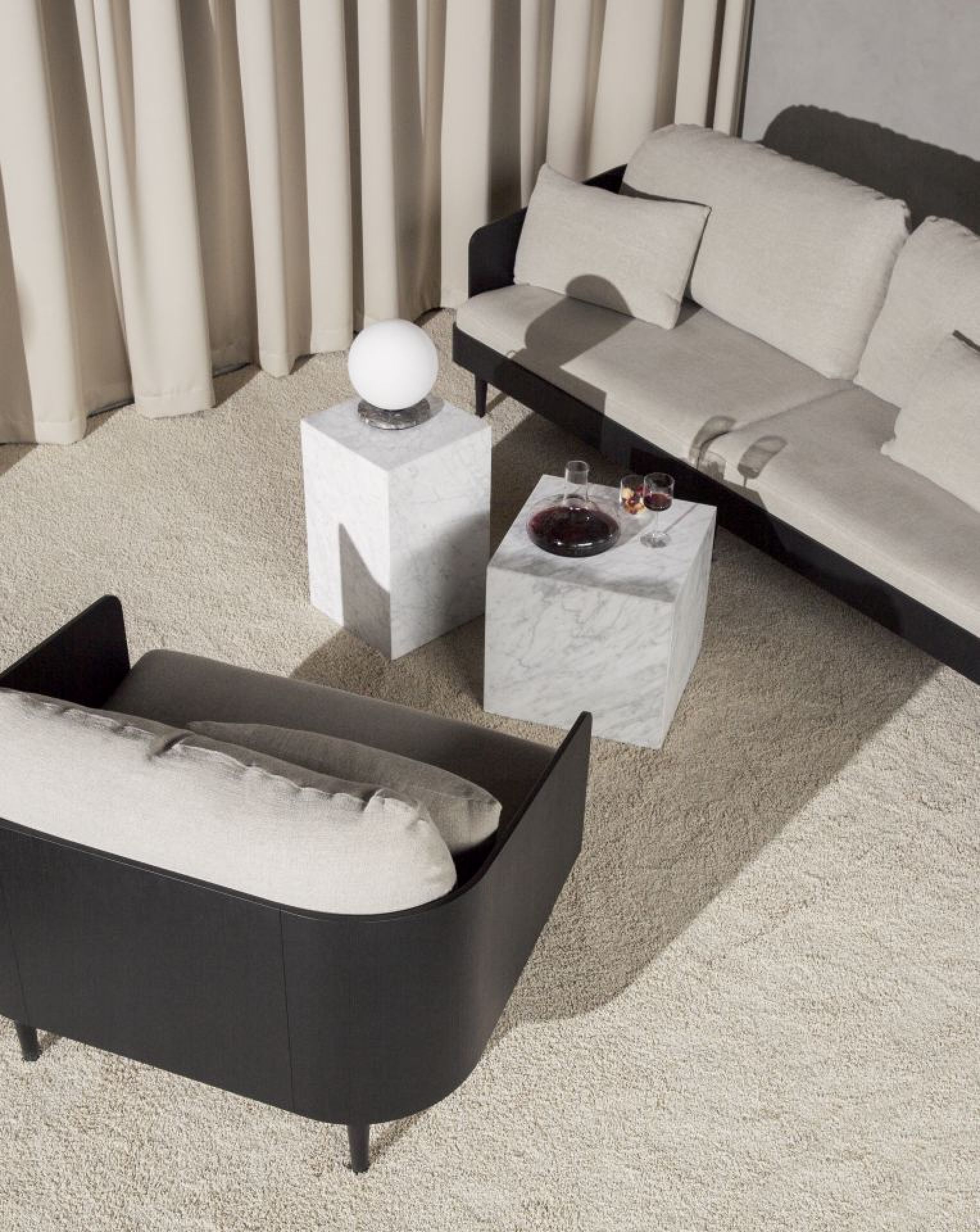 Innenaufnahme mit Audo Wine Breather Karaffe auf Marmortisch, Sofa und Sessel in stilvollem Wohnzimmer.