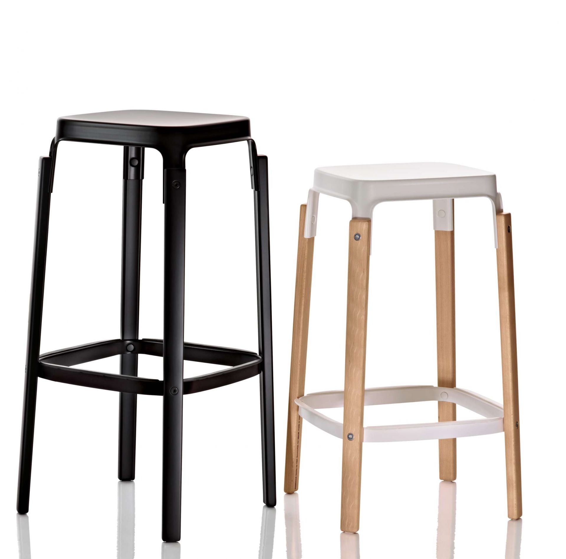 Zwei Steelwood Hocker von Magis, einer schwarz, einer weiß mit Holzbeinen.