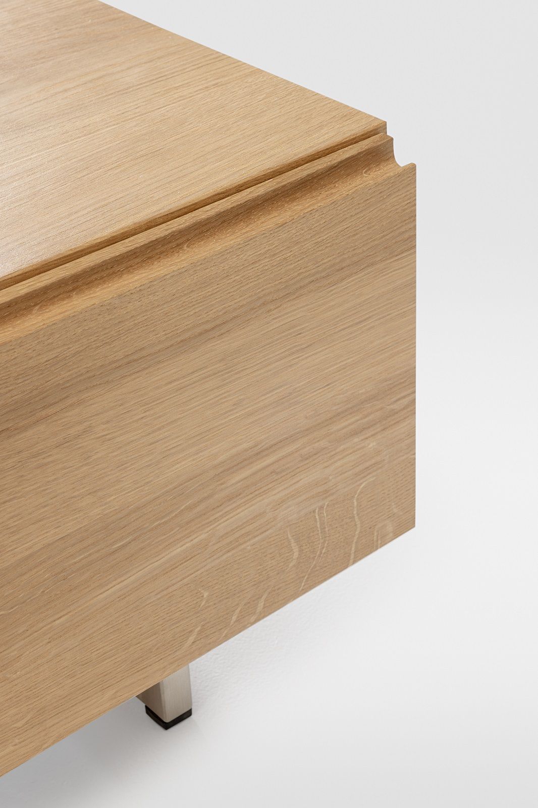 Detailansicht: Podest Sideboard aus Massivholz mit feiner Holzmaserung und Metallfuß.