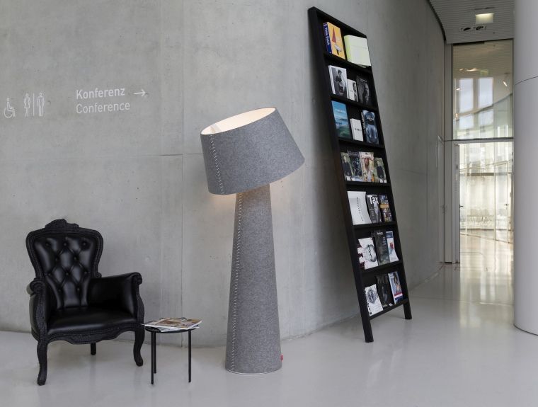 Alice XL Stehleuchte von Moree, graue Stofflampe im Interieur mit Sessel und Bücherregal.