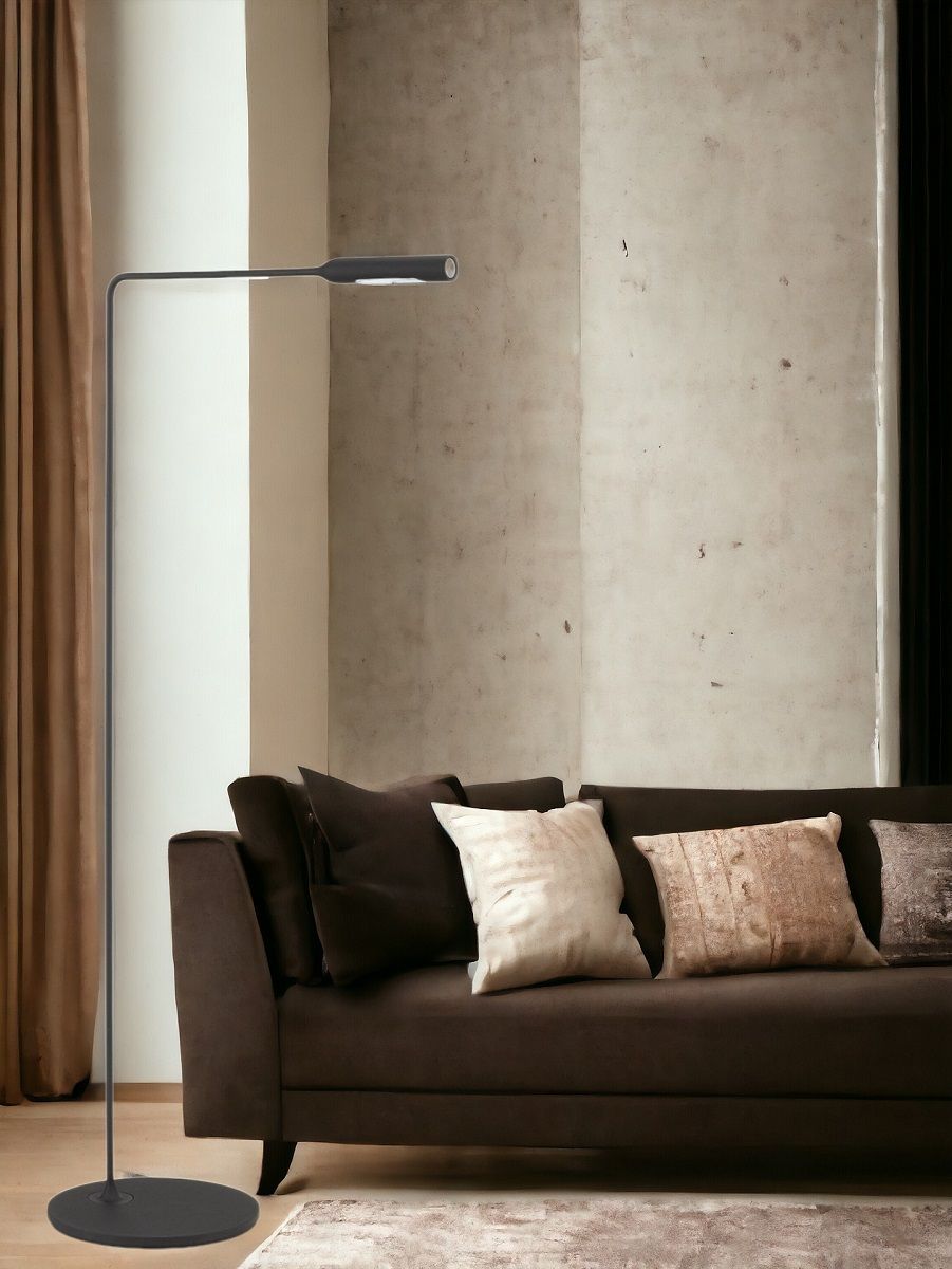 Schlanke, schwarze Flo Floor Stehleuchte von Lumina neben einem braunen Sofa im Wohnzimmer.