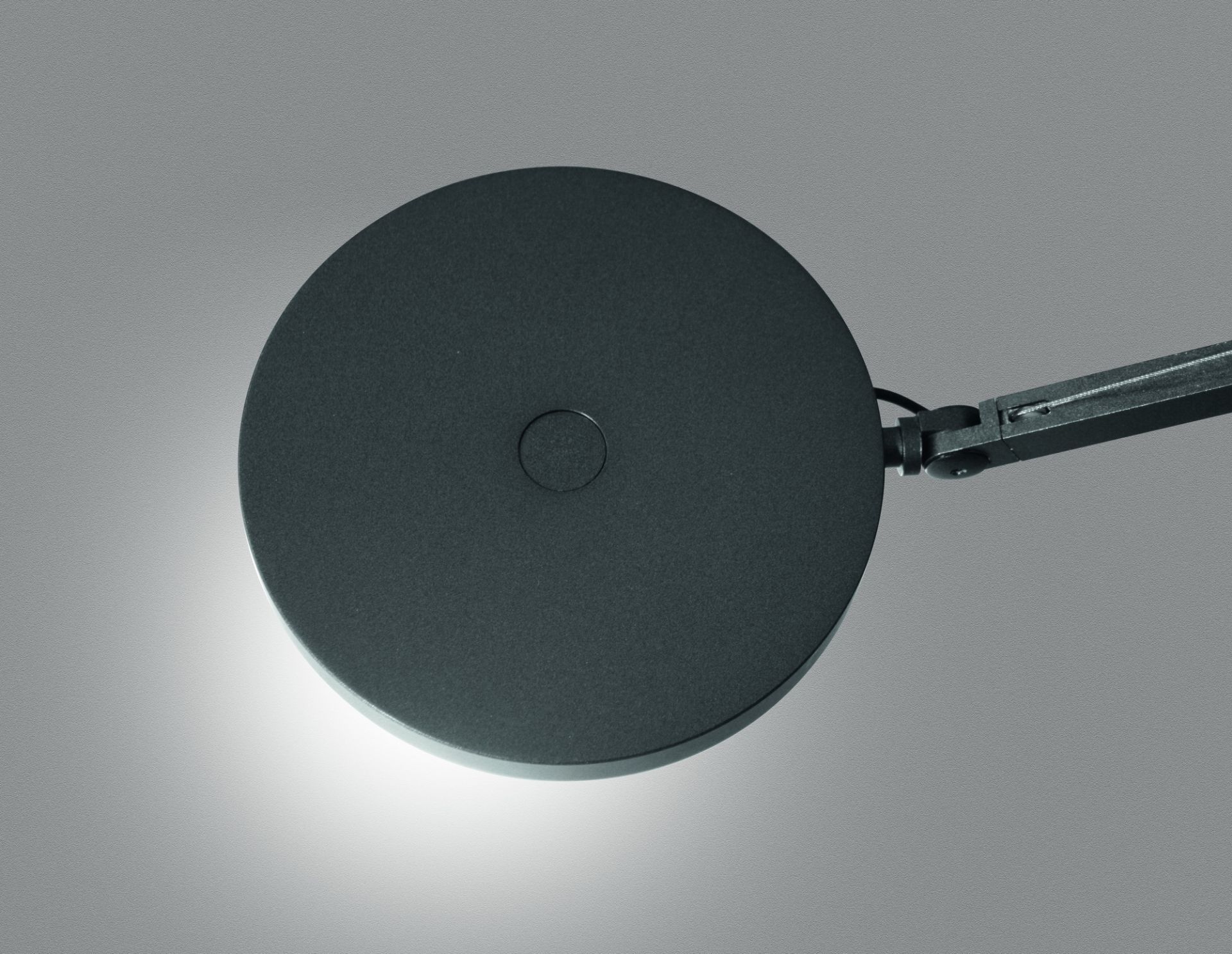 Detailaufnahme des runden Leuchtenkopfes der Demetra Tischleuchte von Artemide in Anthrazit.