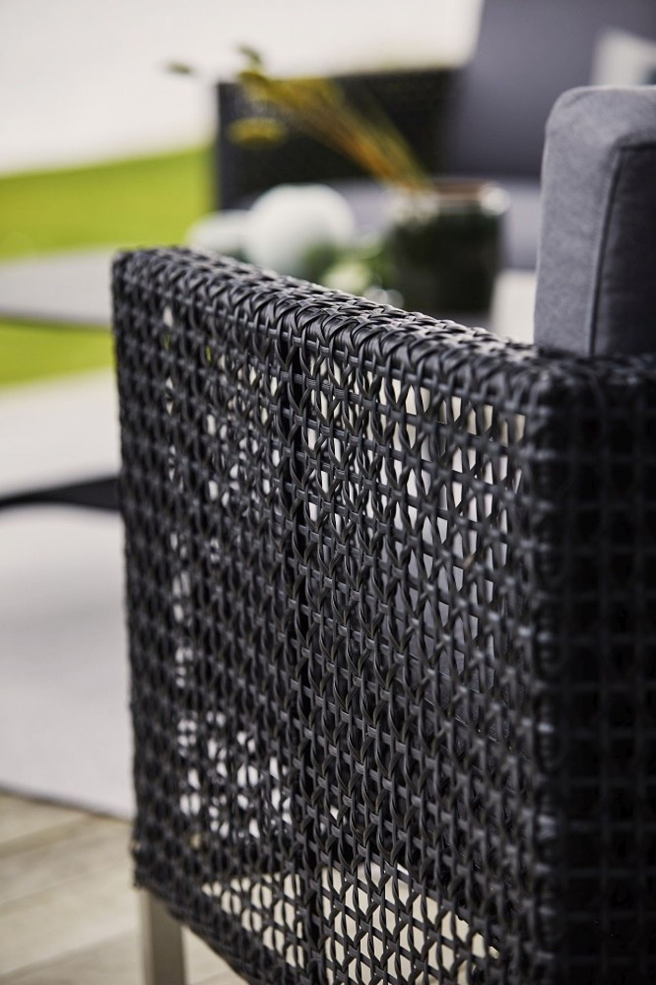 Detailansicht: Cane-Line Connect Loungesessel mit schwarzem Rattan-Geflecht und grauem Kissen. Outdoor-Möbel für Garten und Terrasse.