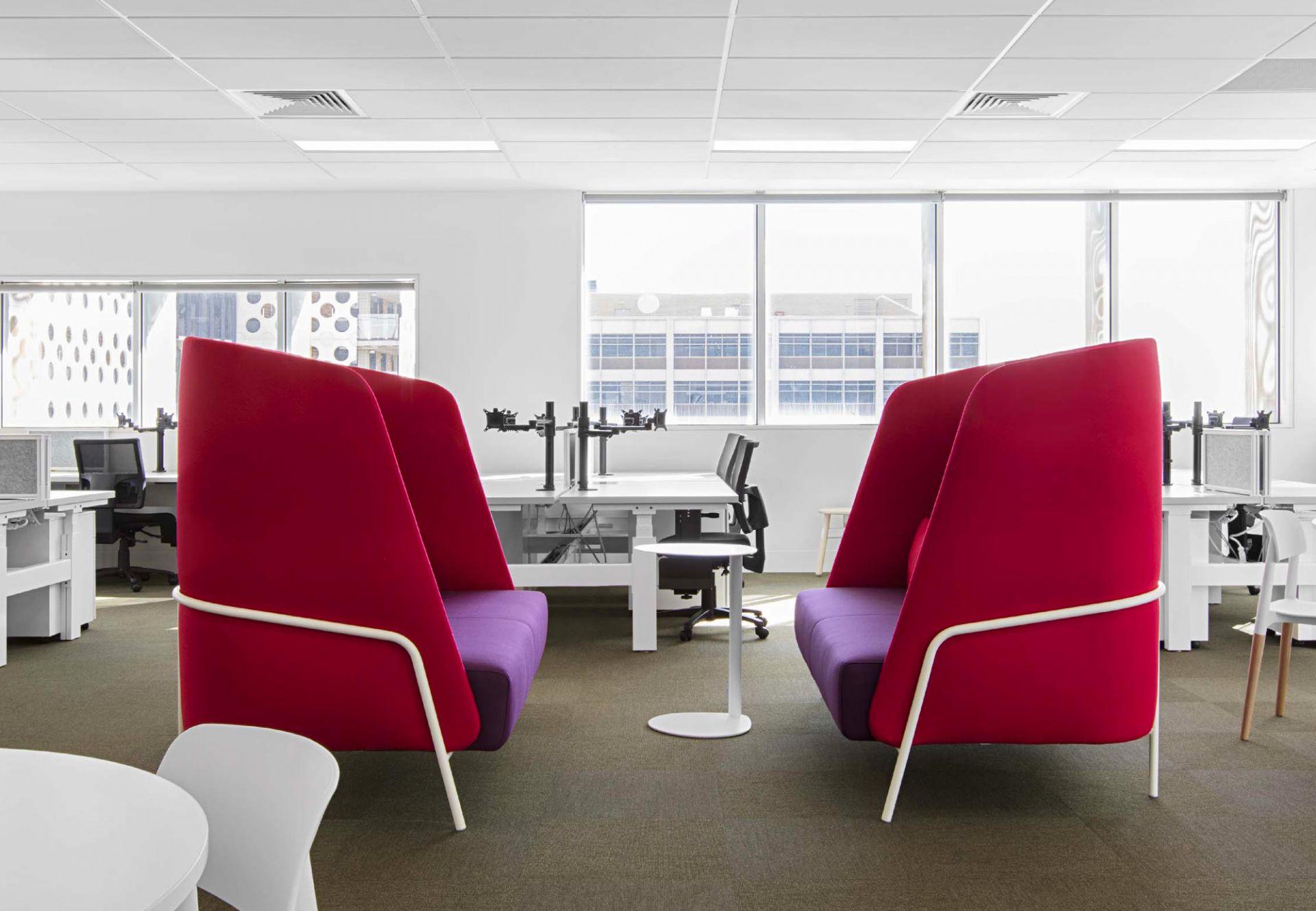 Büro mit zwei roten Loungesesseln und einem weißen Easy Boy Beistelltisch aus Aluminium.