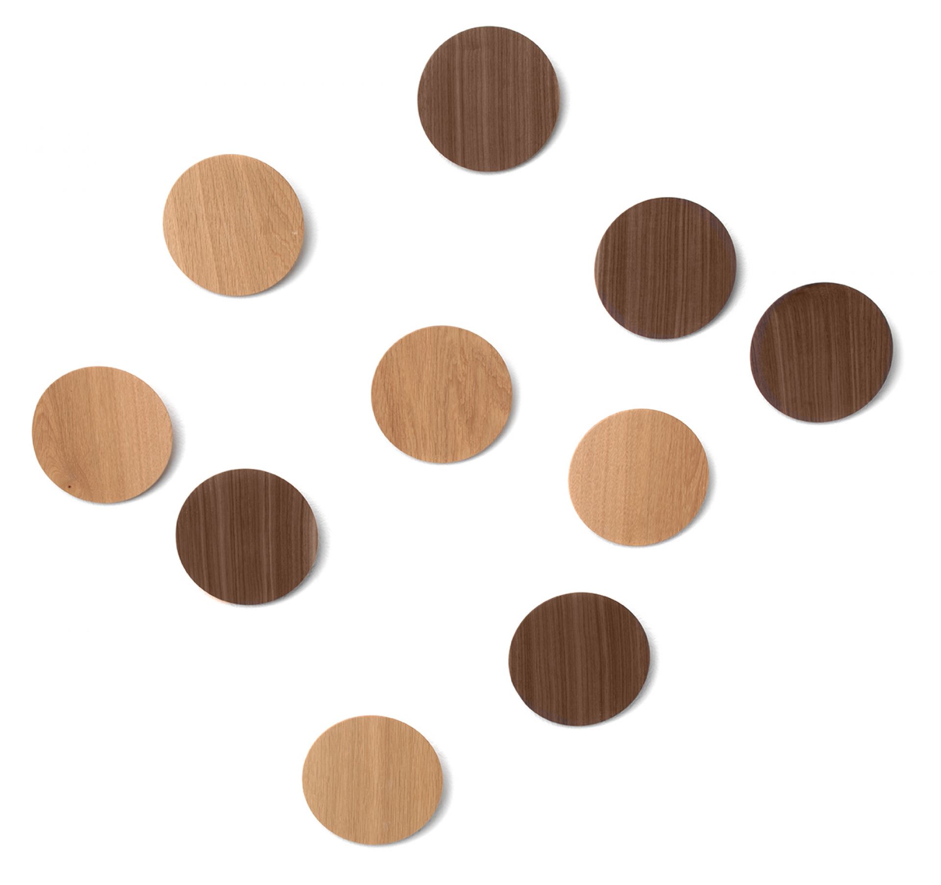 Disk Wandhaken von Schönbuch: Mehrere runde Wandhaken aus hellem und dunklem Holz an einer weißen Wand.
