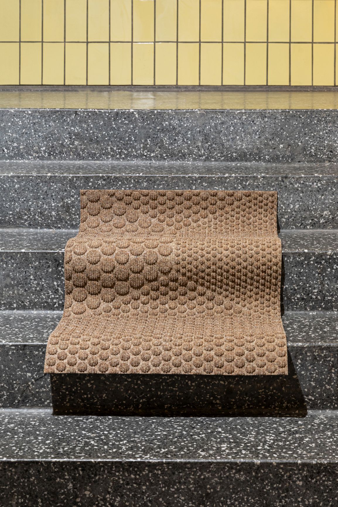 Hex Fußmatte Desert von Heymat auf einer Treppe, braune Schmutzfangmatte mit Noppenmuster.