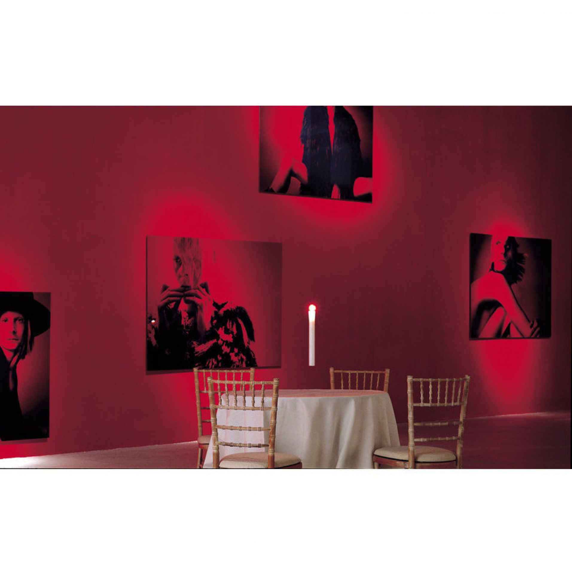 Fly Candle Fly! Hängekerze von Ingo Maurer über Esstisch in rotem Raum mit Bildern.