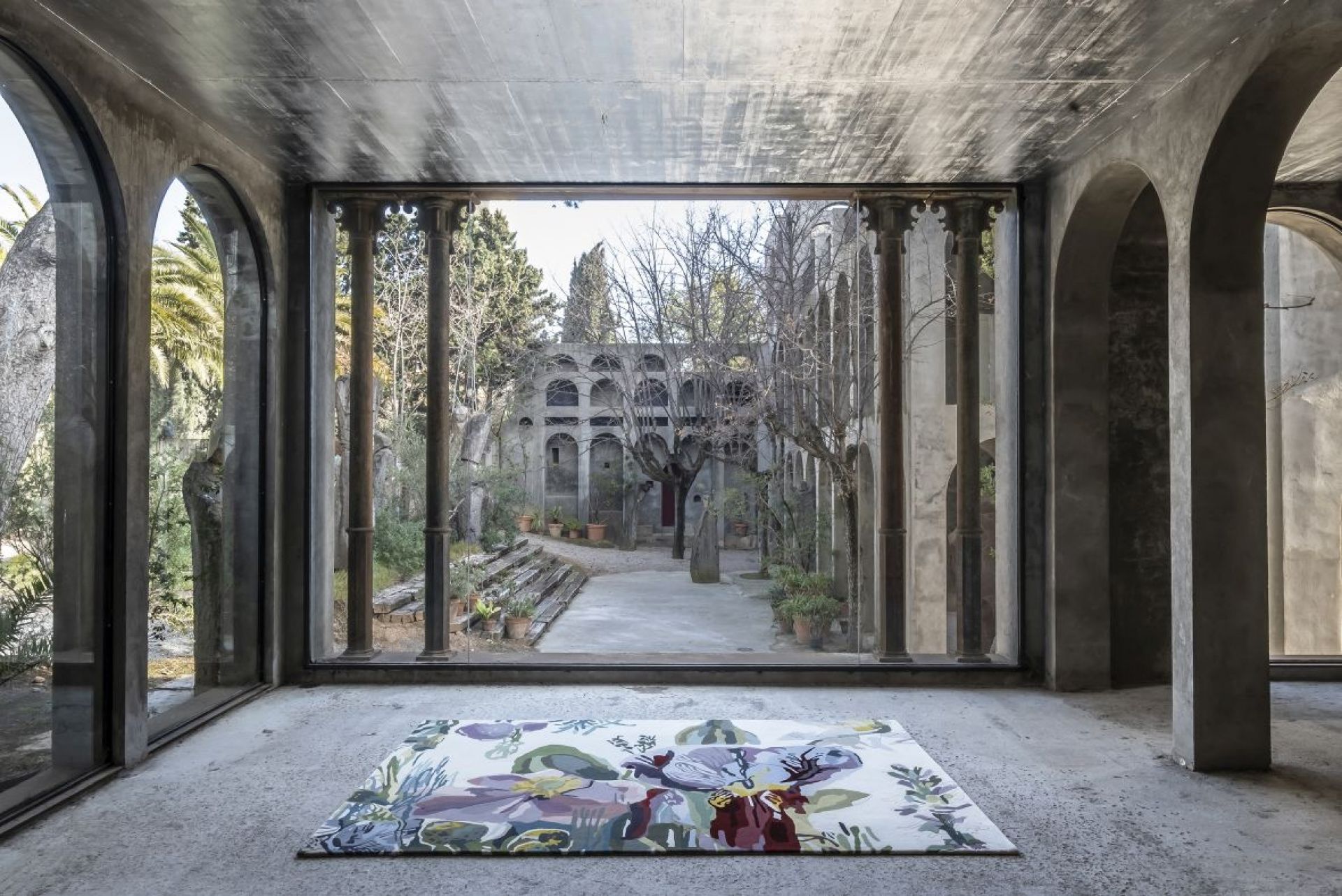 Nanimarquina Flora Backyard Teppich mit floralem Muster in modernem Raum mit Gartenblick.